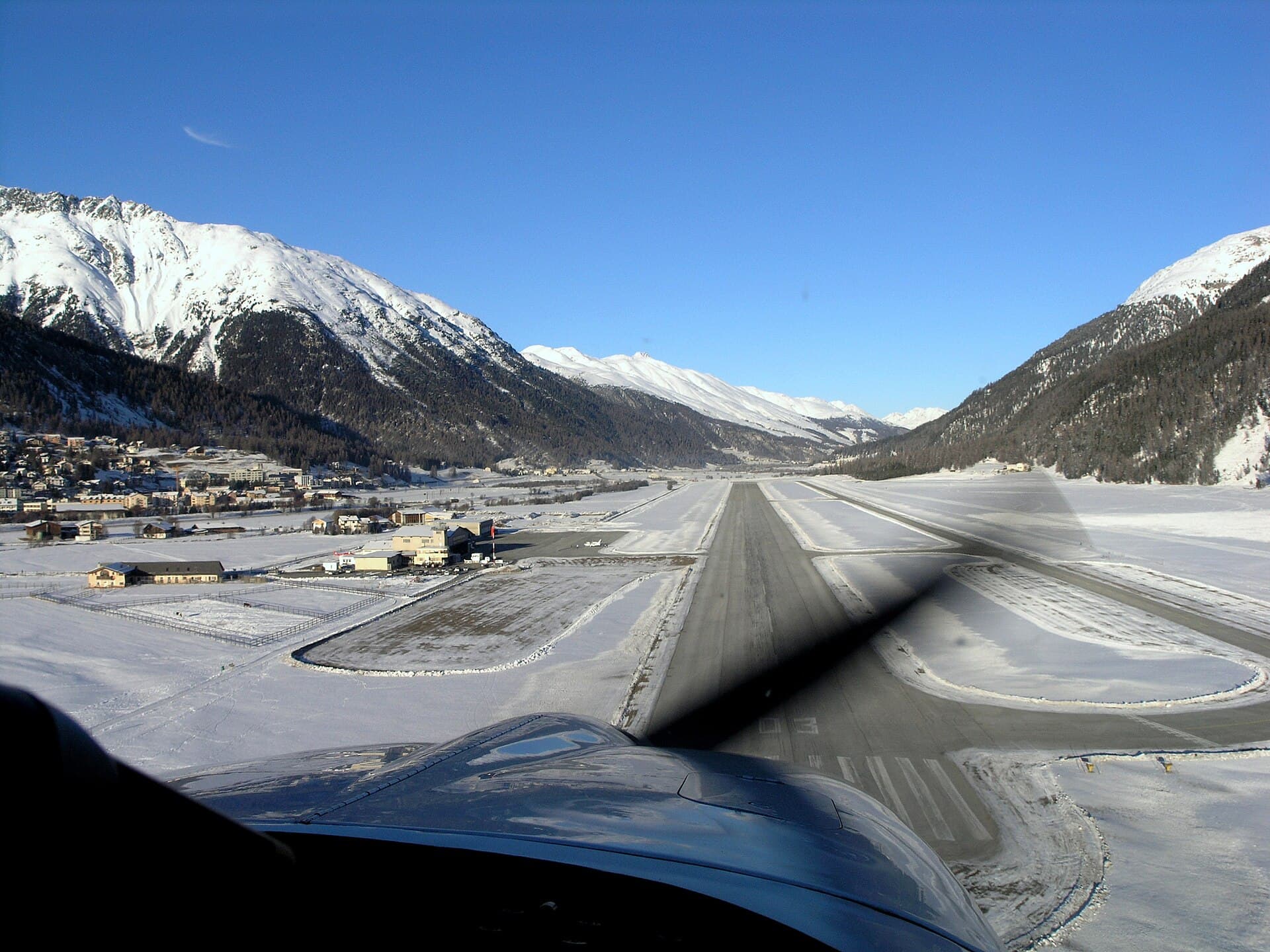 Atterrissage à l'aéroport alpine d'Engadin enneigé, entouré de montagnes